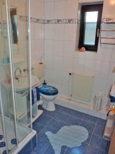 a bathroom with a blue toilet and a sink at Ferienwohnung "Herrmi" Objekt ID 12050-5 in Waren