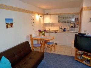 a living room with a couch and a table and a kitchen at Ferienwohnung "Herrmi" Objekt ID 12050-5 in Waren