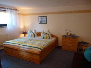 a bedroom with a large wooden bed and a dresser at Ferienwohnung "Herrmi" Objekt ID 12050-5 in Waren