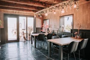 a dining room with tables and chairs and windows at Bed and Breakfast de WoerdT in Altforst +30 photos