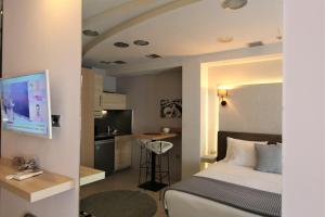 a hotel room with a bed and a kitchen at Aiolos Apartments Ermou 64 2nd Floor suites in Athens