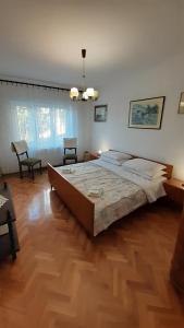 een slaapkamer met een groot bed en een houten vloer bij K&M Apartment in Opatija
