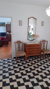 een kamer met een dressoir, 2 stoelen en een spiegel bij K&M Apartment in Opatija