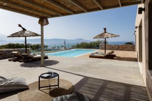 a villa with a swimming pool and a patio at Aristotelis Residence in Petres