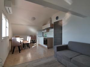 sala de estar con sofá, mesa y cocina en Apartment Porat 2 en Ugljan