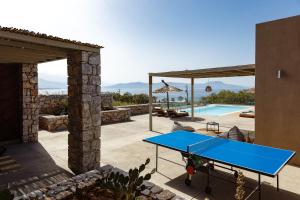 a blue ping pong table on a patio next to a pool at Aristotelis Residence in Petres