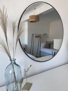un espejo en una habitación con un jarrón y un dormitorio en Inxpress Luxury Apartment Driffield en Great Driffield