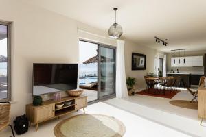 a living room with a large television and a dining room at Aristotelis Residence in Petres