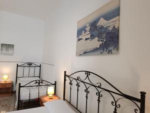 a bedroom with two beds and a painting on the wall at Casa Il Pesco in Noto