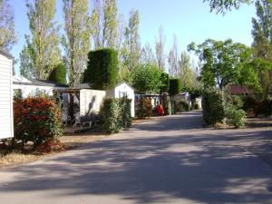 una entrada arbolada con una casa y árboles en Camping les salins de la gardiole, mobile home 6 personnes en Vic-la-Gardiole