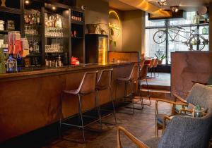 a bar with a row of bar stools at Max Brown Hotel Museum Square, part of Sircle Collection in Amsterdam
