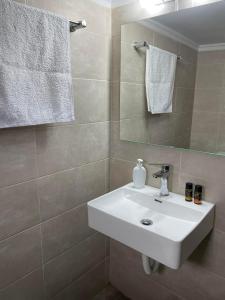 a bathroom with a white sink and a mirror at Chania Nice Apartment 3 in Chania Town