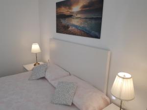 a bedroom with a bed with two pillows and a picture on the wall at Luz de Valencia in Valencia