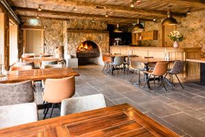 a restaurant with tables and chairs and a fireplace at Le Lignely in Durbuy