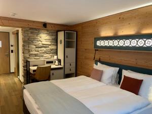 a bedroom with a bed and a desk and a kitchen at Hotel Interlaken in Interlaken