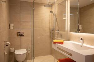 een badkamer met een douche, een wastafel en een toilet bij Haus Bader in Steinbach am Attersee