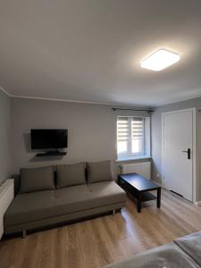 a living room with a couch and a table at Hotel City in Gniezno