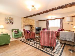 a living room with chairs and a fireplace at Ruskin House in Moreton in Marsh