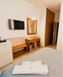 a room with three white pillows and a television on the wall at Castro Hotel in Amoudara Herakliou