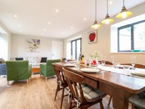 a dining room with a wooden table and green chairs at Ruskin House in Moreton in Marsh