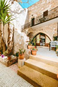 a stone building with stairs and potted plants at Bozzali Deluxe Hotel in Chania