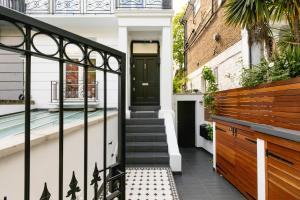 a house with a black door and a staircase at PenthouseStays Chelsea - Luxury King / Queen Bed Studios - near King's Road in London