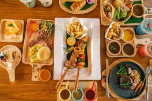 una mesa de madera cubierta con platos de comida y tazones de comida en The Tide Resort en Bangsaen