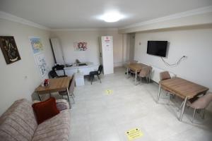 sala de estar con sofá, mesas y TV en Trigo Hotel en Uchisar