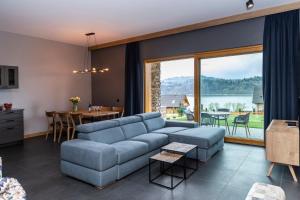 a living room with a blue couch and a table at udanypobyt Apartamenty Czorsztyn Panorama 2 B in Czorsztyn +92 photos