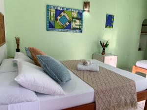 a bedroom with a large bed with pillows on it at Pousada Lanai in Itacaré