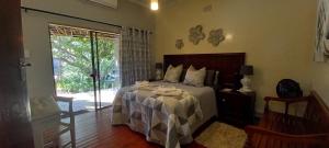 una camera con letto e porta scorrevole in vetro di Mitat Guesthouse a Beaufort West