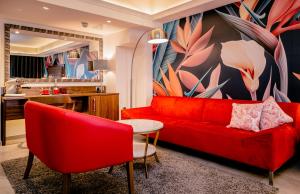 a red couch and two chairs in a living room at AX The Victoria Hotel in Sliema