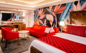 a hotel room with a bed and a red couch at AX The Victoria Hotel in Sliema