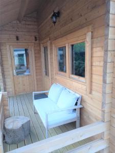 a wooden cabin with a white couch on the deck at 't Hertje in Ermelo