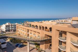 a view of a building with the ocean in the background at Minos Ambassador Suites & Spa - Adults only in Rethymno Town