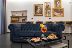a living room with a blue couch and a glass of wine at Hart Boutique Hotel in Naples