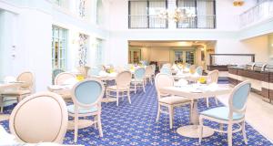 a restaurant with tables and chairs in a room at AX The Victoria Hotel in Sliema