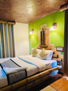 Wild Elephant Resort في Kallar Vattiyar: غرفة نوم بسريرين وجدار أخضر