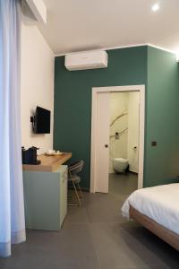 a bedroom with a bed and a bathroom with a toilet at Hart Boutique Hotel in Naples