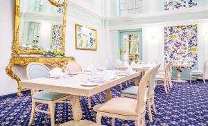 a dining room with tables and chairs and a mirror at AX The Victoria Hotel in Sliema