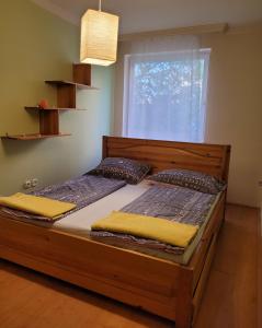 2 camas individuales en una habitación con ventana en Lara Apartman, en Debrecen