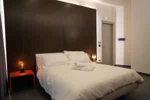 a bedroom with a large white bed with a brown headboard at Hart Boutique Hotel in Naples