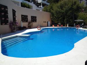 Una gran piscina azul en un edificio. en Cala Marina, en La Herradura