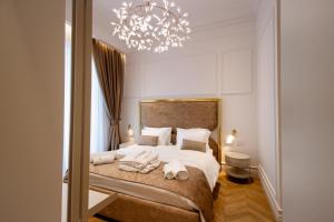 um quarto com uma cama e um lustre em The Crown Boutique Hotel & SPA em Tirana