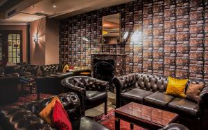 a bar with leather couches and a fireplace at AX The Victoria Hotel in Sliema