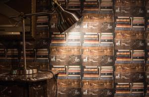 a lamp on a table next to a wall with books at AX The Victoria Hotel in Sliema