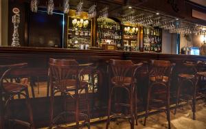 a bar with wooden stools in a room at AX The Victoria Hotel in Sliema