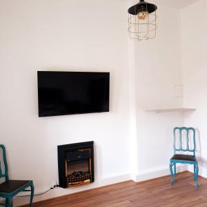 a living room with a fireplace and a flat screen tv at Centrum ARTLwowska in Warsaw +39 photos