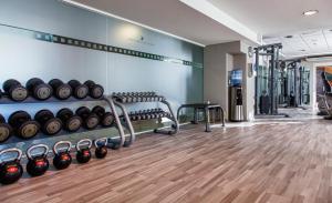 a gym with rows of dumbbells on a wall at AX The Victoria Hotel in Sliema