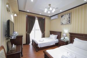 a hotel room with two beds and a television at HUMSON BULOQ SANATORIUM in Khumson